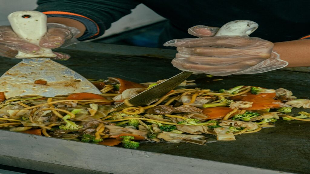 A chef stir-frying vegetables in a wok with a burst of steam,the chinese kitchen.