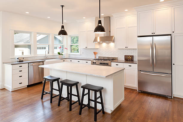 A modern kitchen light fixtures illuminated by minimalist pendant lights and recessed lighting.