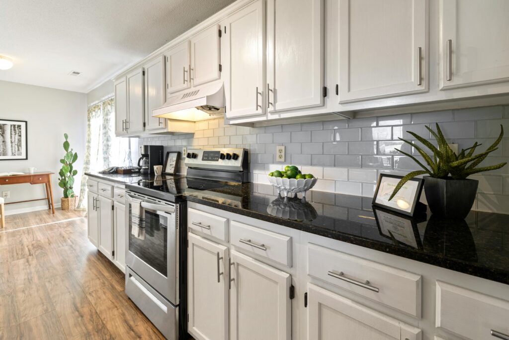 Peel-and-apply backsplash tiles being installed in a modern kitchen.